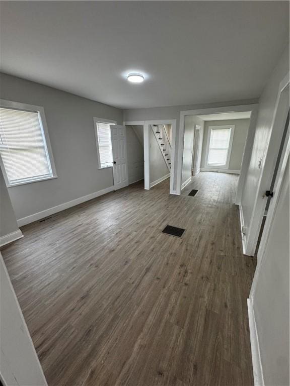 317 W State St, Albion, NY 14411 - unfurnished living room with stairs and dark wood-style floors