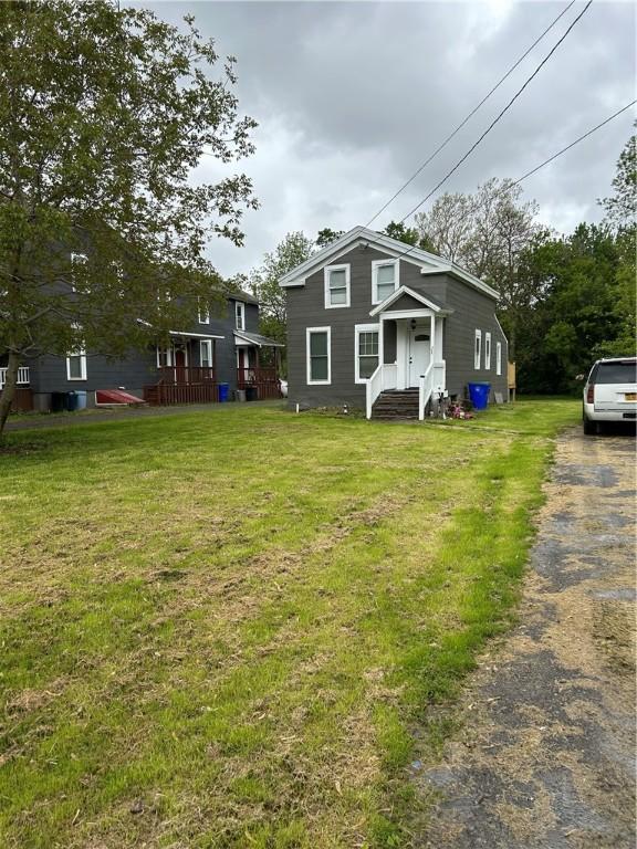317 W State St, Albion, NY 14411 - view of front of home featuring a front lawn, asphalt driveway, and entry steps