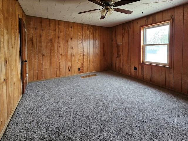 330 Victory Hwy, Erwin, NY 14870 - carpeted empty room featuring visible vents, wood walls, and ceiling fan
