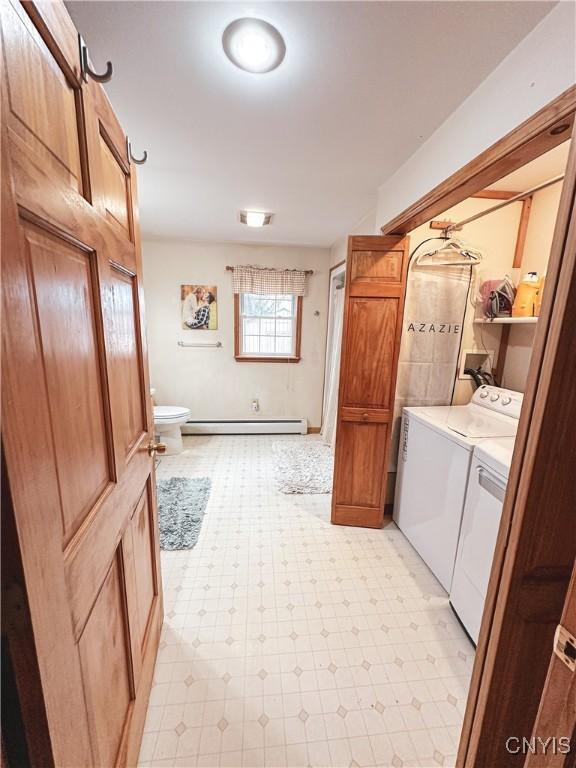4062 Port St, Richland, NY 13142 - laundry room featuring washing machine and clothes dryer, light flooring, and a baseboard radiator