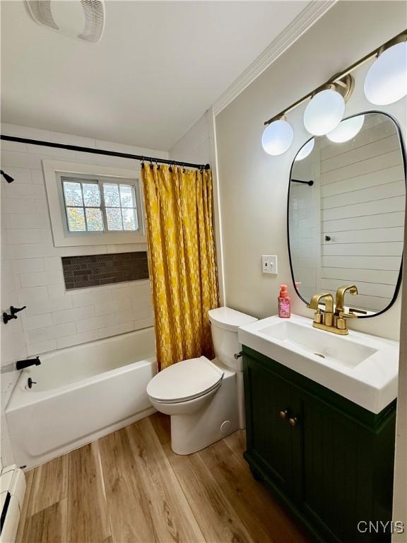 4062 Port St, Richland, NY 13142 - bathroom featuring a baseboard radiator, vanity, toilet, wood finished floors, and shower / bathtub combination with curtain