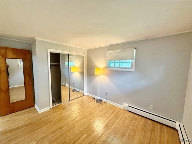 4062 Port St, Richland, NY 13142 - unfurnished bedroom featuring wood finished floors, a baseboard radiator, baseboards, a closet, and crown molding