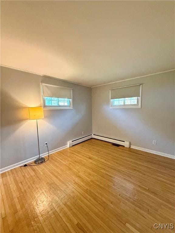 4062 Port St, Richland, NY 13142 - unfurnished room featuring wood finished floors, baseboards, plenty of natural light, and a baseboard heating unit