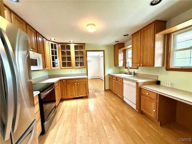 4062 Port St, Richland, NY 13142 - kitchen featuring appliances with stainless steel finishes, light countertops, a sink, light wood finished floors, and brown cabinets