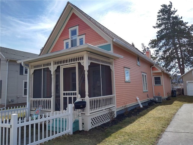 view of side of property featuring a sunroom, central air condition unit, fence, a chimney, and a lawn