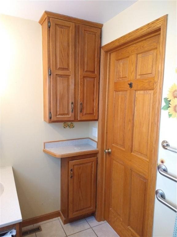 interior space featuring tile patterned floors, vanity, baseboards, and visible vents