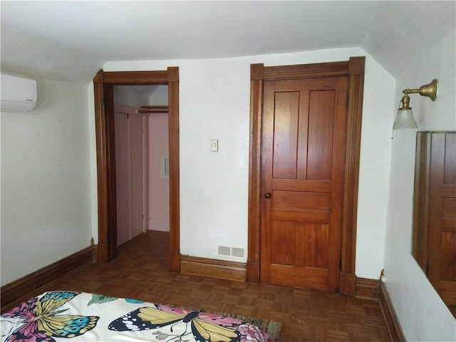 bedroom featuring baseboards, visible vents, a wall unit AC, and vaulted ceiling