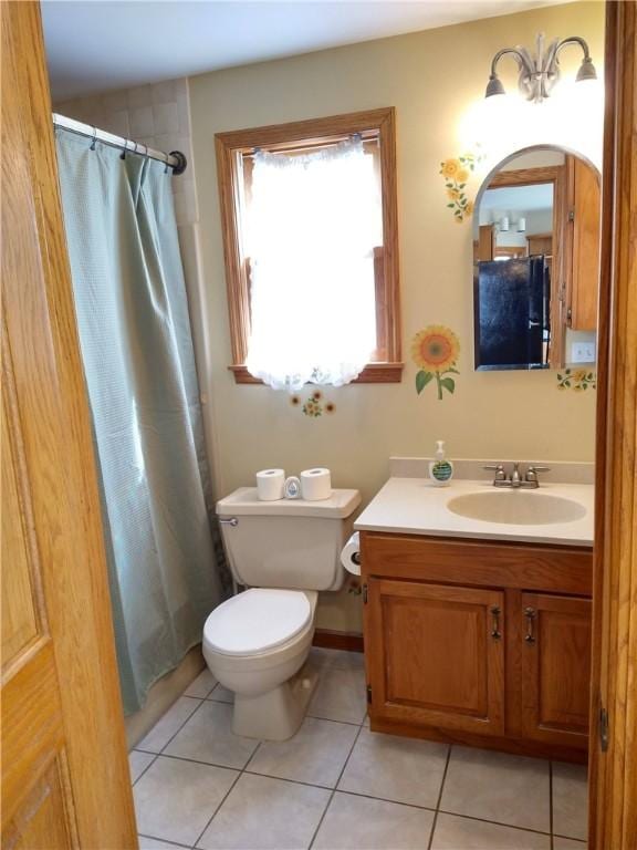 bathroom with tile patterned flooring, vanity, curtained shower, and toilet