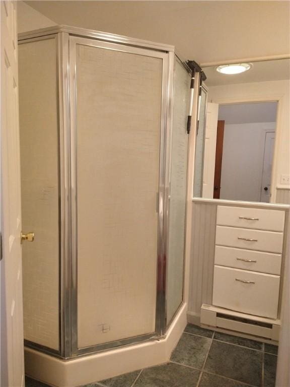 full bathroom with a baseboard heating unit, tile patterned flooring, and a stall shower