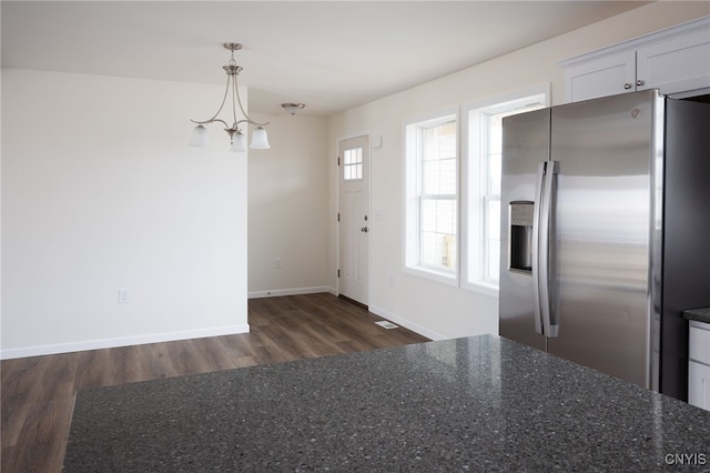 interior space featuring baseboards, wood finished floors, and a notable chandelier