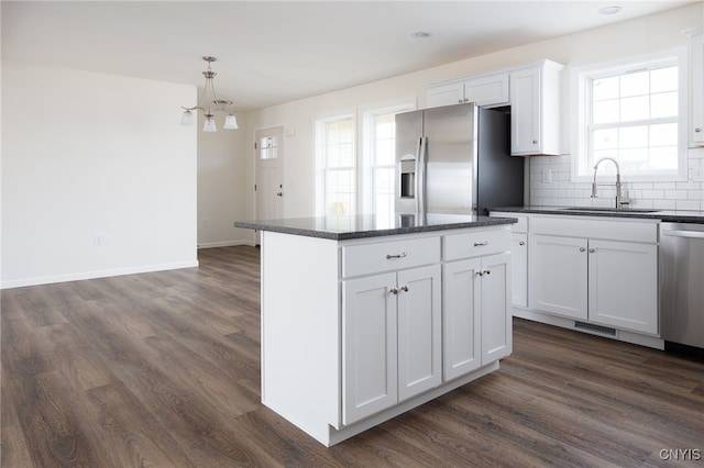 kitchen featuring a chandelier, dark wood finished floors, appliances with stainless steel finishes, and a sink