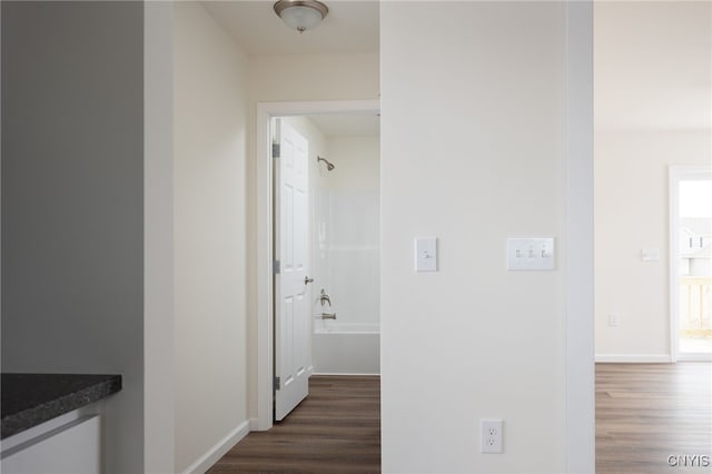 hall featuring baseboards and dark wood-style flooring