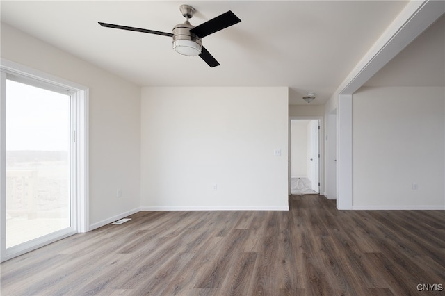 spare room featuring ceiling fan, baseboards, wood finished floors, and visible vents
