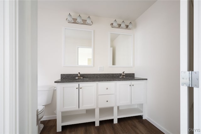 bathroom featuring a sink, toilet, wood finished floors, and baseboards