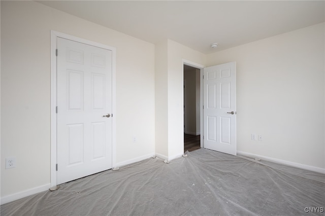 unfurnished bedroom featuring baseboards and carpet