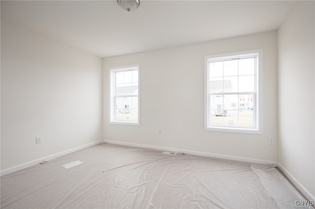 unfurnished room featuring visible vents, baseboards, and light colored carpet