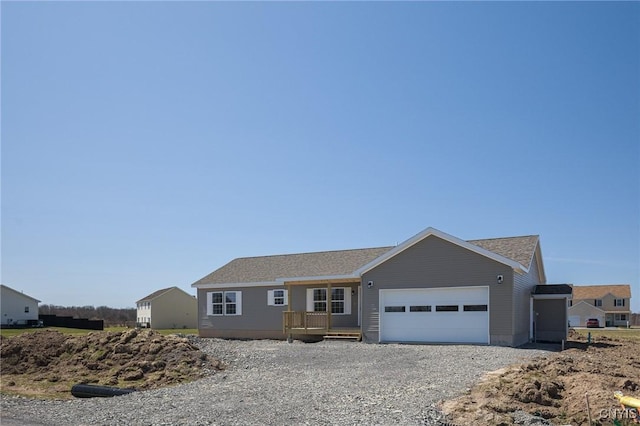 ranch-style home with a garage and gravel driveway