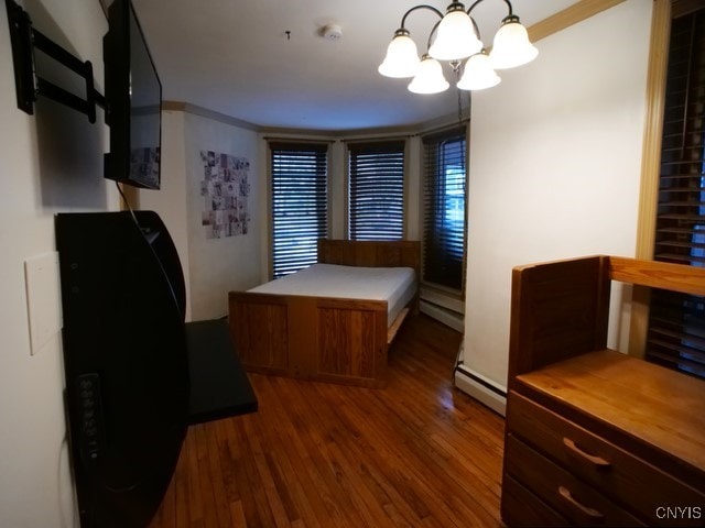 36 Lincoln Ave, Cortland, NY 13045 - bedroom with wood finished floors, an inviting chandelier, a baseboard heating unit, and crown molding