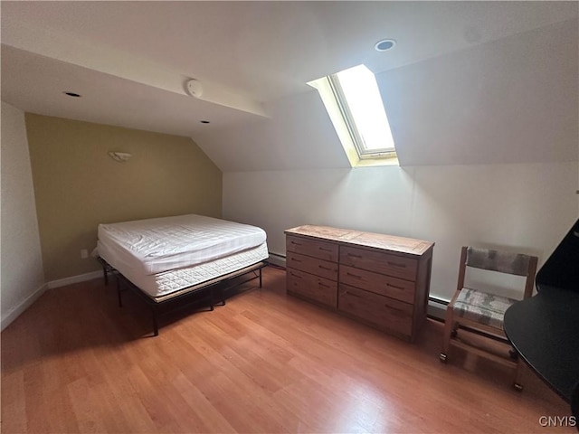 36 Lincoln Ave, Cortland, NY 13045 - bedroom featuring baseboards, vaulted ceiling with skylight, a baseboard heating unit, and light wood-type flooring