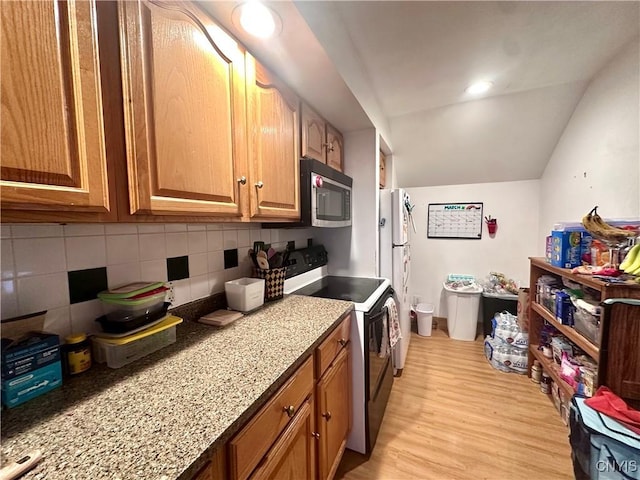36 Lincoln Ave, Cortland, NY 13045 - kitchen featuring light wood finished floors, tasteful backsplash, lofted ceiling, stainless steel microwave, and electric range