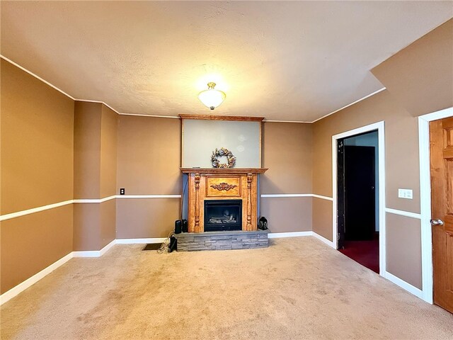 unfurnished living room featuring baseboards, a fireplace with raised hearth, and carpet