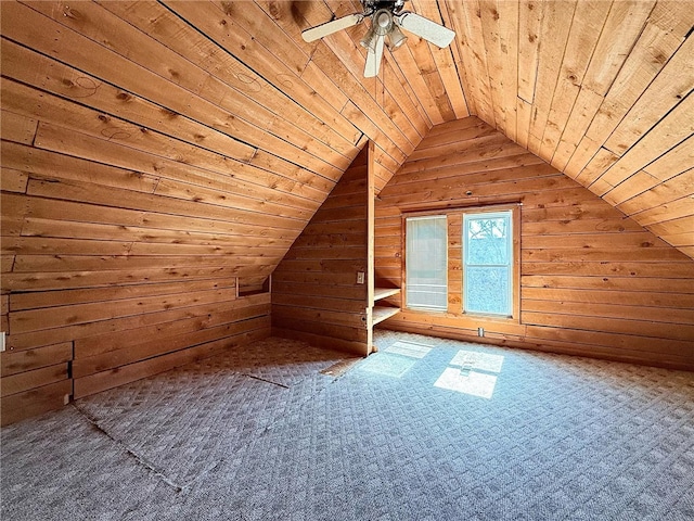 additional living space featuring vaulted ceiling, wooden ceiling, wood walls, and a ceiling fan