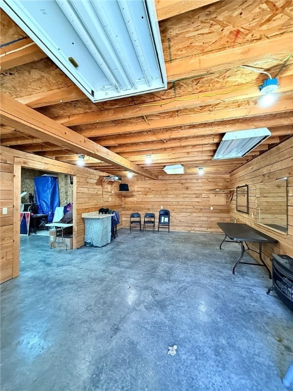 misc room featuring wooden walls and concrete flooring