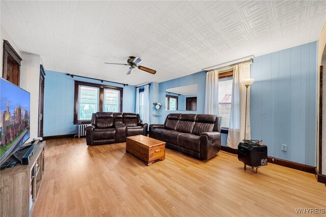 2486 Willow Ave, Niagara Falls, NY 14305 - living room with baseboards, light wood-type flooring, radiator, and a ceiling fan
