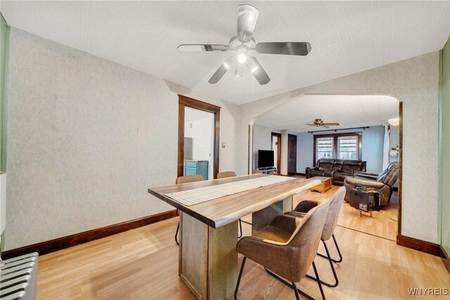 2486 Willow Ave, Niagara Falls, NY 14305 - dining area featuring arched walkways, light wood-type flooring, and a ceiling fan