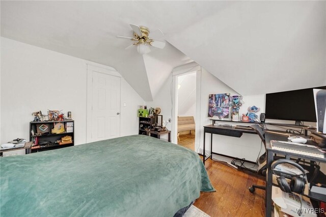 2486 Willow Ave, Niagara Falls, NY 14305 - bedroom with a ceiling fan, connected bathroom, lofted ceiling, and wood finished floors