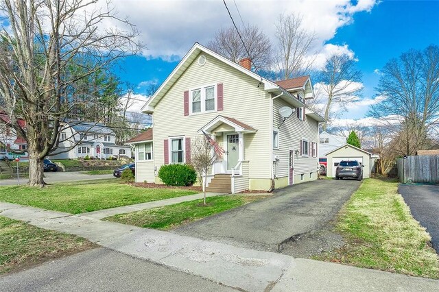 120 Westmont Ave, Elmira, NY 14905 - view of front of property featuring a front lawn, a garage, an outbuilding, aphalt driveway, and a chimney