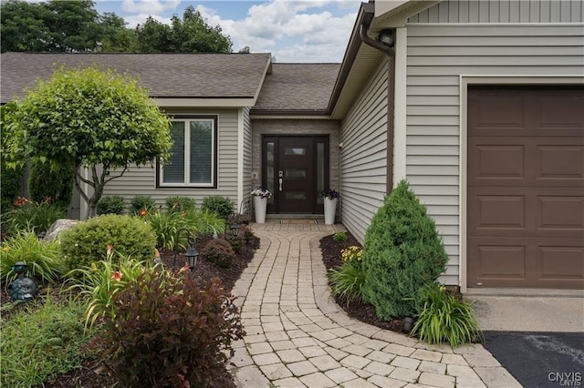 22036 Riverbend Dr W, Le Ray, NY 13601 - doorway to property featuring a shingled roof and a garage