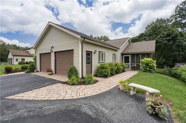 22036 Riverbend Dr W, Le Ray, NY 13601 - ranch-style house featuring a sunroom, driveway, a front lawn, and an attached garage