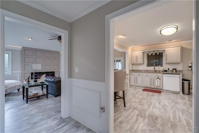 22036 Riverbend Dr W, Le Ray, NY 13601 - hallway featuring wainscoting, crown molding, a decorative wall, and a sink