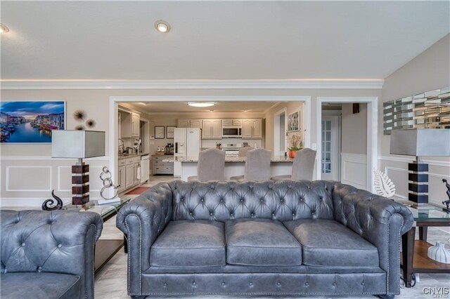 22036 Riverbend Dr W, Le Ray, NY 13601 - living area with a decorative wall, a wainscoted wall, and crown molding