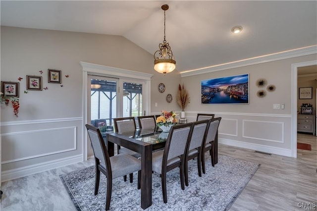 22036 Riverbend Dr W, Le Ray, NY 13601 - dining space with light wood finished floors, lofted ceiling, wainscoting, a decorative wall, and visible vents