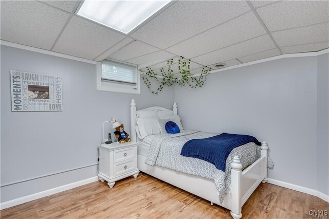 22036 Riverbend Dr W, Le Ray, NY 13601 - bedroom featuring baseboards, light wood-style flooring, and a drop ceiling