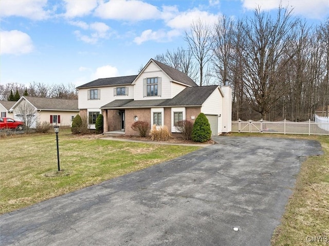 view of front of property featuring aphalt driveway, a gate, fence, an attached garage, and a front lawn