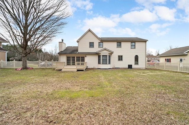 rear view of house with a wooden deck, a fenced backyard, a shingled roof, a yard, and a chimney