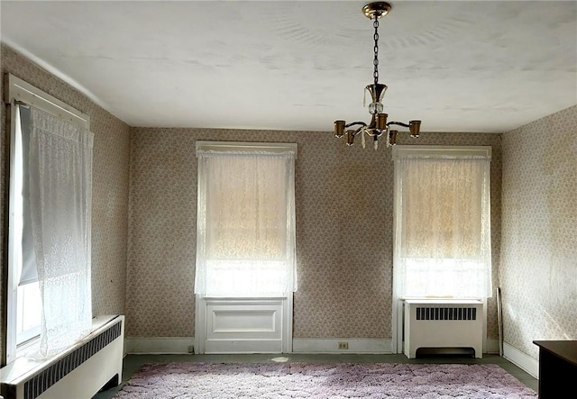 810 River Rd, Sanford, NY 13754 - unfurnished dining area featuring radiator, a chandelier, healthy amount of natural light, and wallpapered walls