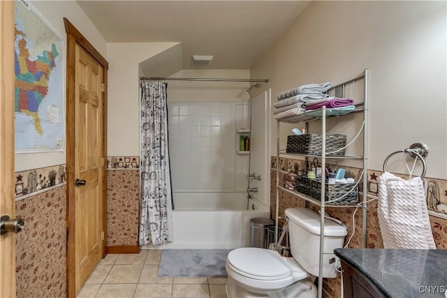 bathroom featuring toilet, vanity, shower / bathtub combination with curtain, wainscoting, and tile patterned flooring