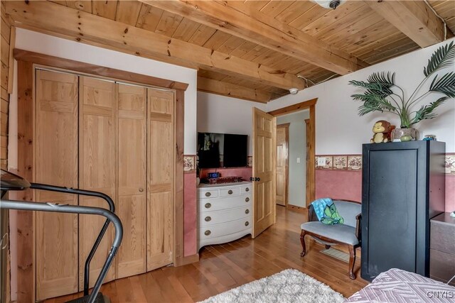 bedroom with wood finished floors, beam ceiling, and wood ceiling