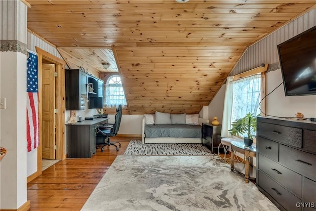 bedroom featuring wood ceiling, light wood-style floors, lofted ceiling, and wooden walls