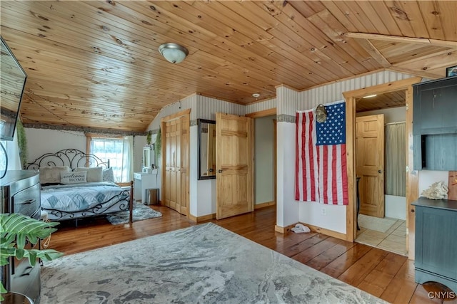unfurnished bedroom with baseboards, vaulted ceiling, wood ceiling, and hardwood / wood-style flooring