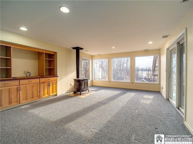 5464 Crestwood Rd, Ellery, NY 14712 - unfurnished living room with carpet flooring, a wood stove, baseboards, visible vents, and recessed lighting