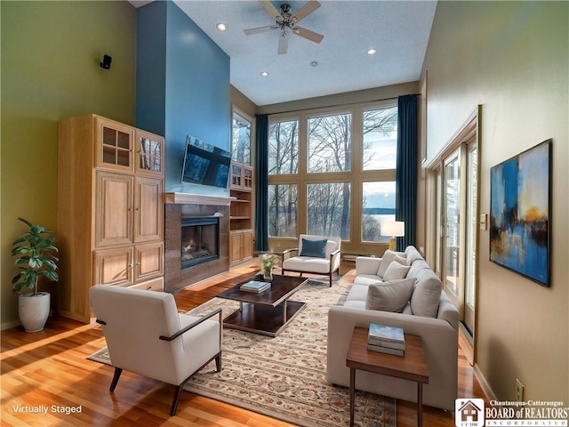 5464 Crestwood Rd, Ellery, NY 14712 - living room featuring baseboards, a high ceiling, a high end fireplace, a ceiling fan, and wood finished floors