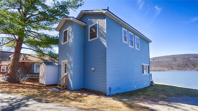 5170 Sunnyside Rd, Italy, NY 14507 - view of home's exterior featuring an outbuilding, a water view, and a storage unit