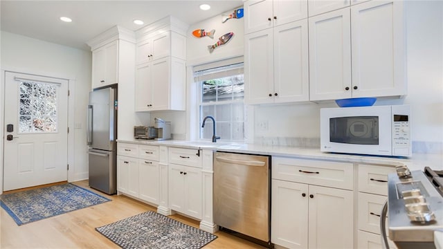 5170 Sunnyside Rd, Italy, NY 14507 - kitchen featuring light countertops, light wood-type flooring, stainless steel appliances, a sink, and white cabinets
