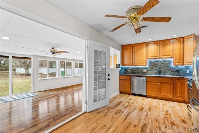 kitchen featuring a sink, tasteful backsplash, dishwasher, brown cabinetry, and ceiling fan