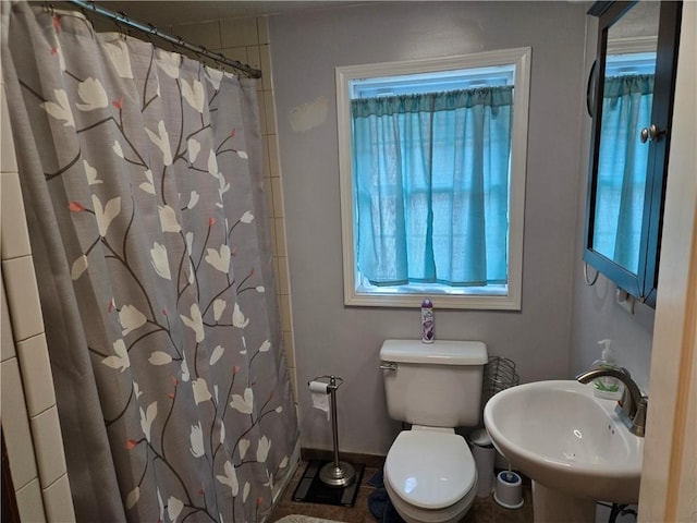 bathroom with baseboards, a sink, toilet, and a shower with shower curtain